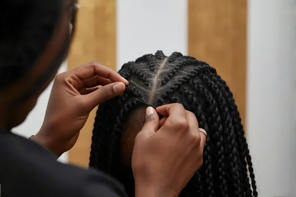 Hair extensions being applied with a sew-in technique
